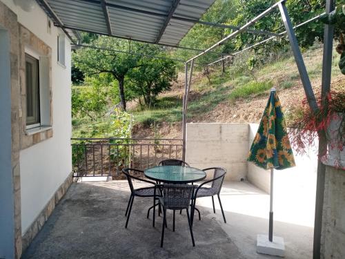 a patio with a glass table and chairs on it at Apartmani Bosco in Tivat