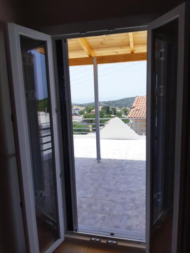 a sliding glass door with a view of a patio at Α Peaceful Nest in Volimes