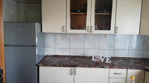 una cucina con mobili bianchi e un frigorifero di NEVERSEA beachfront 2 bedroom apartament a Constanţa