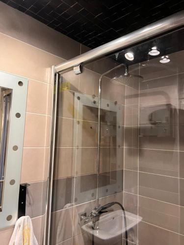 une douche avec une porte vitrée dans une salle de bain dans l'établissement Justcozy chambre indépendante #2, à Lille