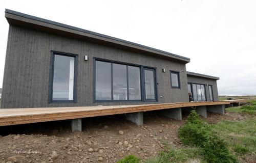 a house on a platform with windows on it at Eyri Seaside Houses in Hvammstangi