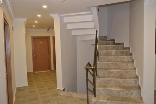 a staircase in a home with white walls and wooden floors at Britannia Hotel Village in Kemer