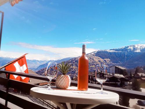 a bottle of wine and two glasses on a table at Superbe appartement au centre de la station in Nendaz