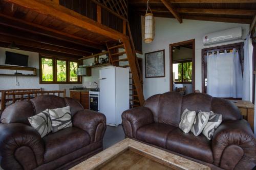 two brown leather couches in a living room at Pousada Moradas da Silveira in Garopaba