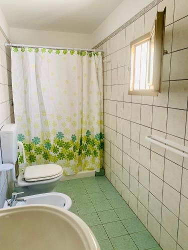a bathroom with a toilet and a shower curtain at Nonna Annunziata in Gemini