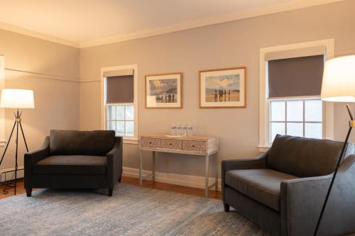 a living room with two chairs and a table at OneSixtyFive, The Inn on Park Row in Brunswick