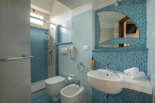 La salle de bains est pourvue d'un lavabo, de toilettes et d'un miroir. dans l'établissement Hotel Casa Yvorio, à Terracine