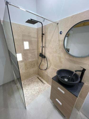 une salle de bain avec un lavabo et un miroir dans l'établissement Home le Vissou, à Cabrières