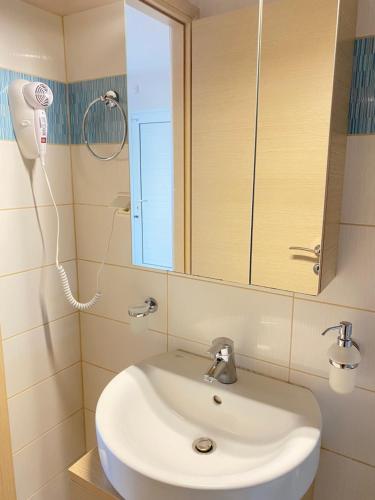 W łazience znajduje się biała umywalka i lustro. w obiekcie Seaside one-bedroom on Chalkis w Chalkidzie