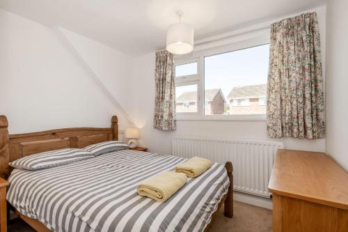 a bedroom with a bed and a desk and a window at 38 Dale End in Brancaster