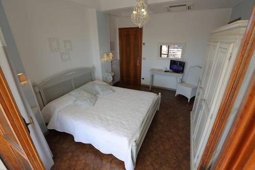 a bedroom with a white bed and a chandelier at Hotel Bergamo Mare Mhotelsgroup in San Bartolomeo al Mare