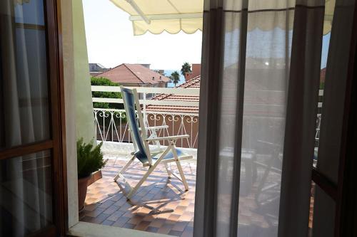 a chair sitting on a patio outside a window at Hotel Bergamo Mare Mhotelsgroup in San Bartolomeo al Mare