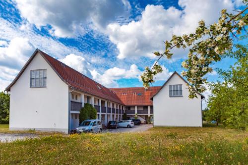 two white buildings in front of a building at Fränkische Landherberge, Hotel Garni in Seßlach