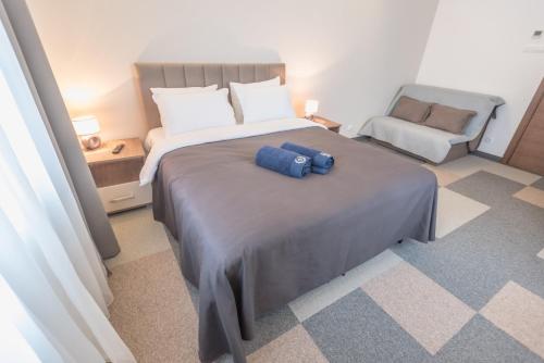a bedroom with a large bed and a chair at Vila Samokres sa bazenom in Banja Koviljača