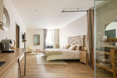 a bedroom with a bed in the middle of a room at Studio chic avec salon et terrasse privée in Tourcoing