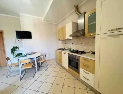 uma cozinha com uma mesa e uma sala de jantar em Casa Lungarno em Empoli