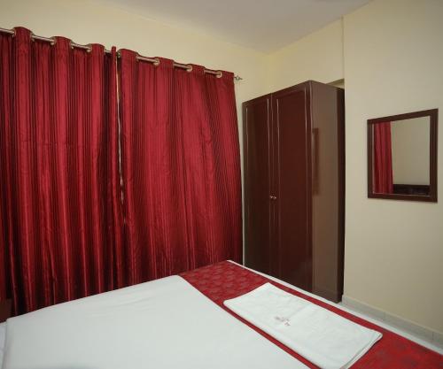 a bedroom with a bed and a red curtain at Al Sharq Hotel in Sharjah