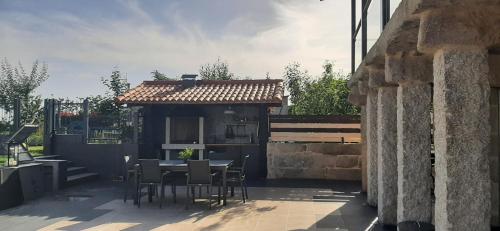a patio with a table and chairs and a building at CASA VACACIONAL ACIO in Ourense
