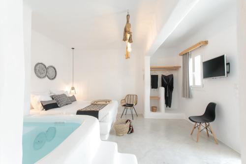 a white room with a bed and a bath tub at Irida Vacation suites in Kastraki Naxou