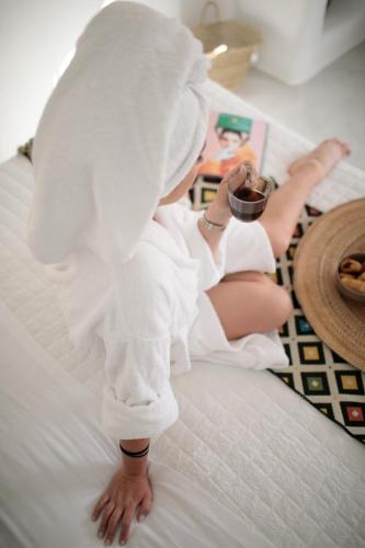 a woman sitting on a bed in a towel at Irida Vacation suites in Kastraki Naxou