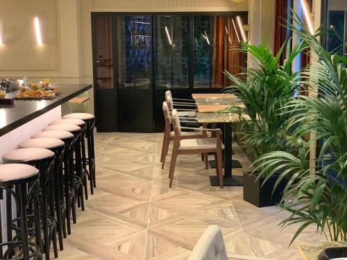 a dining room with a table and chairs and plants at Hotel Le Rocroy in Paris