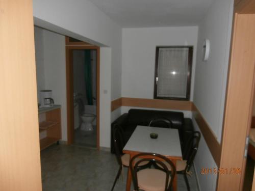 a living room with a table and a couch and a bathroom at Apartments Meni in Drage