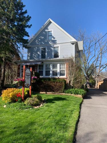 a house with a sign in front of a yard at Ambiance by the Falls Cozy Suite in Niagara Falls