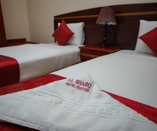 two beds in a hotel room with a sign on them at Al Sharq Hotels Suites in Sharjah