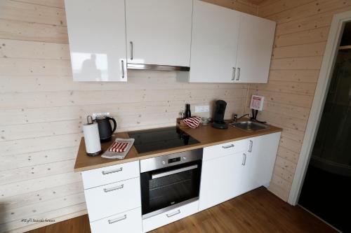 a kitchen with white cabinets and a counter top at Eyri Seaside Houses in Hvammstangi