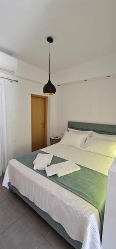 a bedroom with a large bed with a green blanket at Hera gk apts in Chania Town