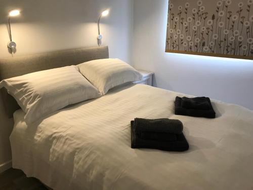 Una cama blanca con dos toallas negras. en 310 Norton Park en Dartmouth