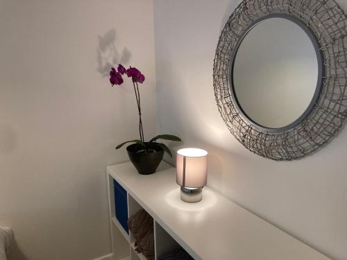 a table with a mirror and a vase with a flower at 310 Norton Park in Dartmouth