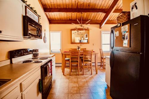 a kitchen with a black refrigerator and a table at Exposed Beam 3BR Modern Mountain Retreat in Thornton