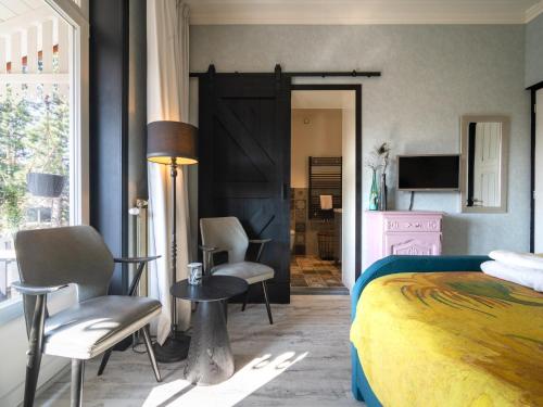 a bedroom with a bed and a table and chairs at Villa Lucia in Rucphen