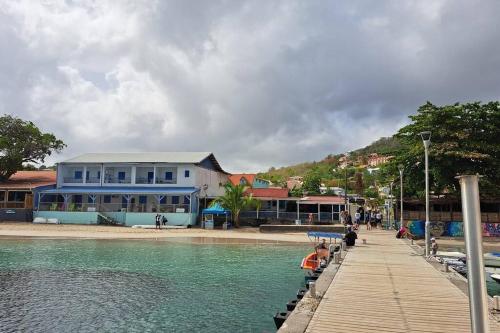 a blue building next to a body of water at T2 PITAYA, Trois-îlets vue mer in Les Trois-Îlets