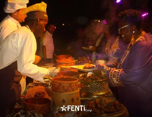 a group of people standing around a table with food at Fenti Nubian Resort in Aswan