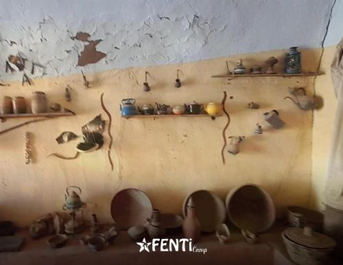 a wall with a bunch of pots and pans on it at Fenti Nubian Resort in Aswan