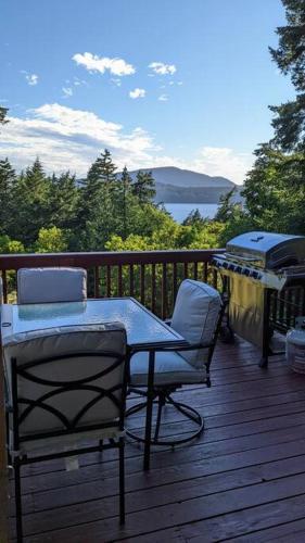 a table and chairs on a deck with a grill at Villa w/ Amazing Bay Views Near Beach w/ Garden, Ping Pong in Eastsound