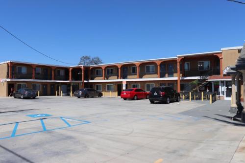 a parking lot with cars parked in front of a building at El Dorado Motel in Gardena