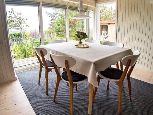a dining room table with a white tablecloth and chairs at 6 person holiday home in Thyholm-By Traum in Thyholm