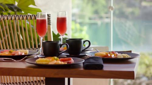 a table with two champagne glasses and plates of food at Hotel Amainah Bacalar Adults Only in Bacalar