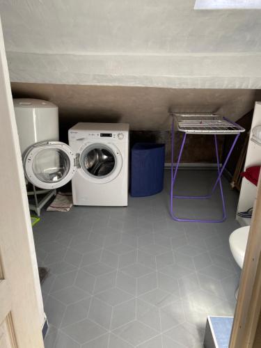 a laundry room with a washing machine and a washer at Petit cocon in Château-Chinon