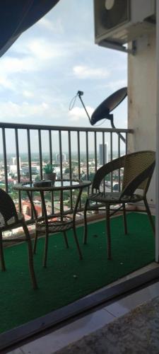 a balcony with two chairs and a bird on a railing at CMK APARTMEN MUTIARA TOWER 3 BEDROOM KOTA BHARU#Netflix in Kota Bharu