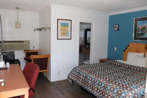 a hotel room with a bed and a desk at El Dorado Motel in Gardena