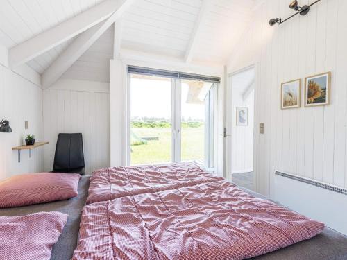 a bedroom with a large bed and a large window at Holiday home Vejers Strand XX in Vejers Strand