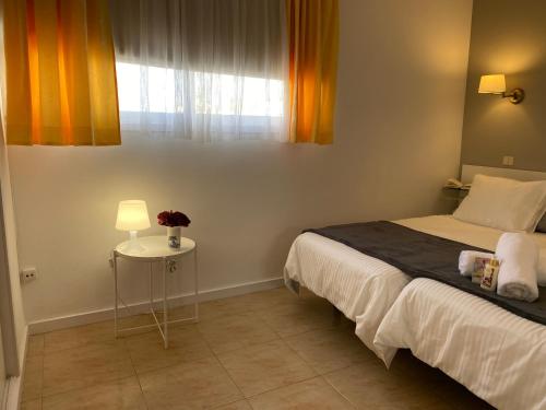 a bedroom with a bed and a table and a window at Bonito apartamento con vistas in Puerto de la Cruz
