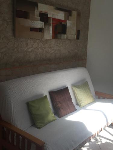 a couch with two pillows and a painting on the wall at villa NYL in Schœlcher