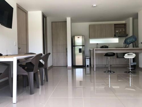 a kitchen with a table and chairs and a refrigerator at Hermoso apartamento en SANTA FE DE ANTIOQUIA in Medellín