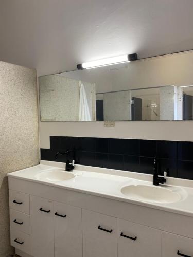 baño con 2 lavabos y espejo grande en Tattersalls Hotel, en Goulburn