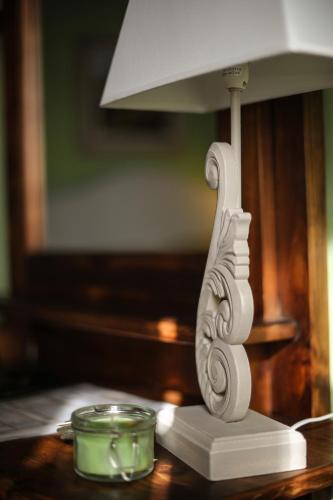 a white lamp sitting on a table with a candle at B&B Le Dimore Mezza Costa in San Casciano in Val di Pesa